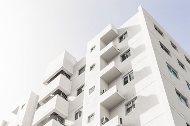 foto-de-baixo-angulo-da-fachada-de-um-edificio-moderno-branco-sob-um-ceu-azul-claro (1)